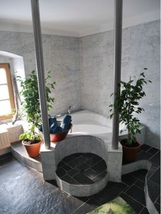 Großes Naturstein-Badezimmer mit Badewanne und Dusche